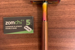 The razor assembled next to the included pack of razor blades