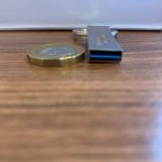 Size comparison of the Moreslon USB flash drive against a one pound coin from the side
