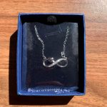 The necklace in the box with the plastic wrap